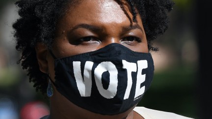 Stacey Abrams wears a face mask reading 