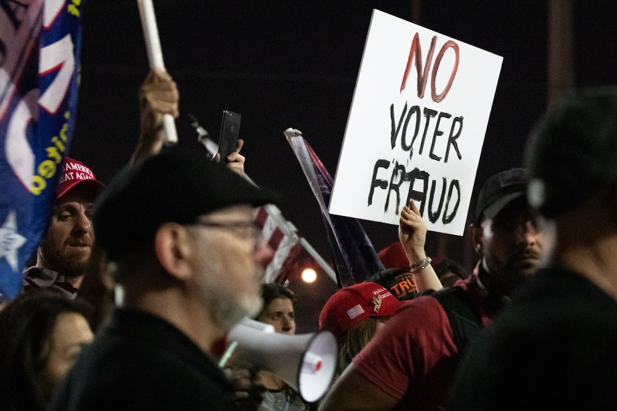 A no voter fraud sign is displayed by a protester in support of President Donald Trump at the Maricopa County Elections Department off