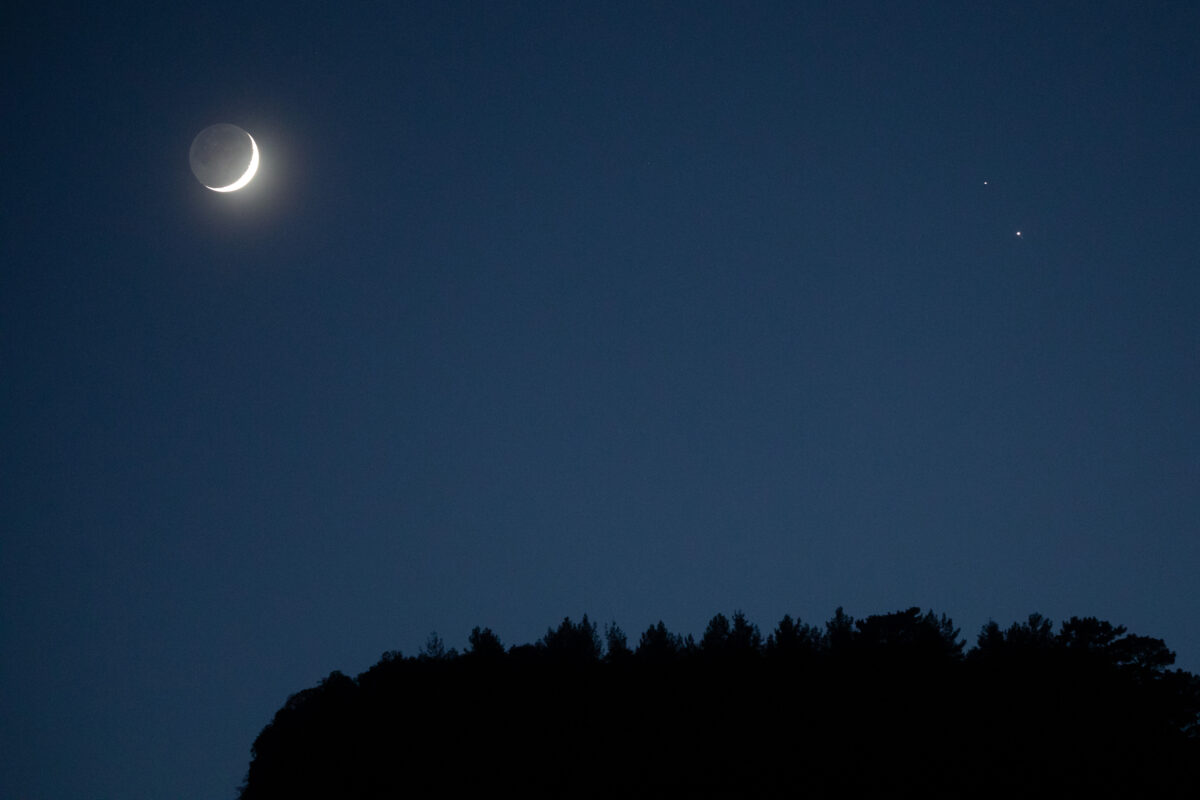 ANTALYA, TURKEY - DECEMBER 17: A crescent moon (L) is seen with Saturn (upper right) and Jupiter (lower right) ahead of their closest visible conjunction on December 17, 2020 in Antalya, Turkey. On December 21, a Jupiter and Saturn conjunction will form a rare "double planet" for the first time in 400 years and will be the closest the two planets have been since 1623. (Photo by Chris McGrath/Getty Images)