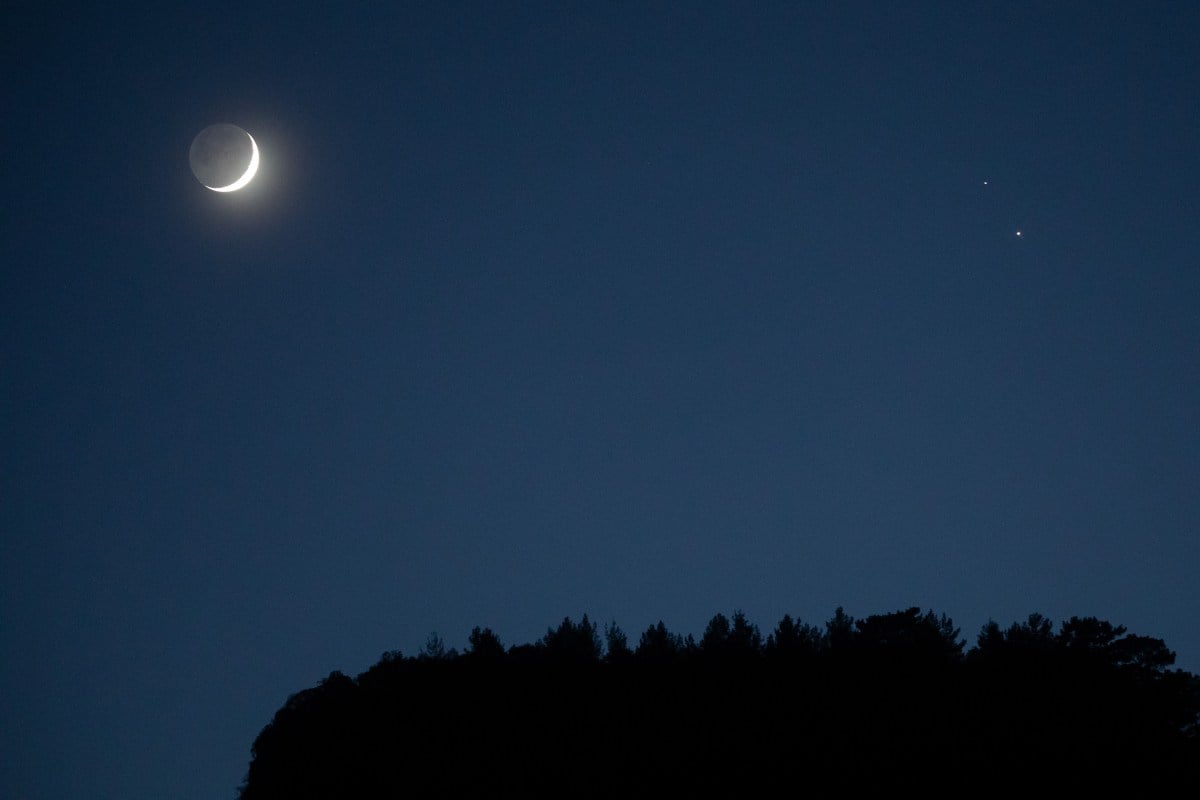 ANTALYA, TURKEY - DECEMBER 17: A crescent moon (L) is seen with Saturn (upper right) and Jupiter (lower right) ahead of their closest visible conjunction on December 17, 2020 in Antalya, Turkey. On December 21, a Jupiter and Saturn conjunction will form a rare "double planet" for the first time in 400 years and will be the closest the two planets have been since 1623. (Photo by Chris McGrath/Getty Images)