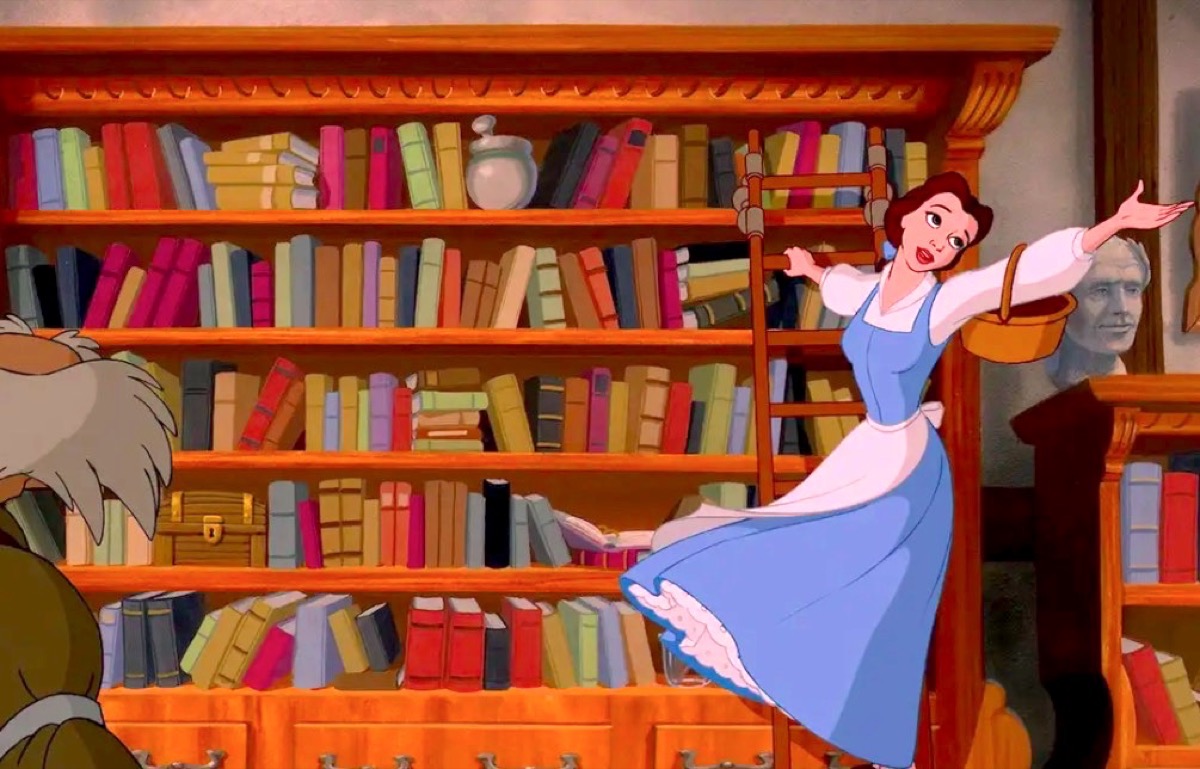 Belle singing on a ladder on a book shelf in Disney's Beauty and the Beast.