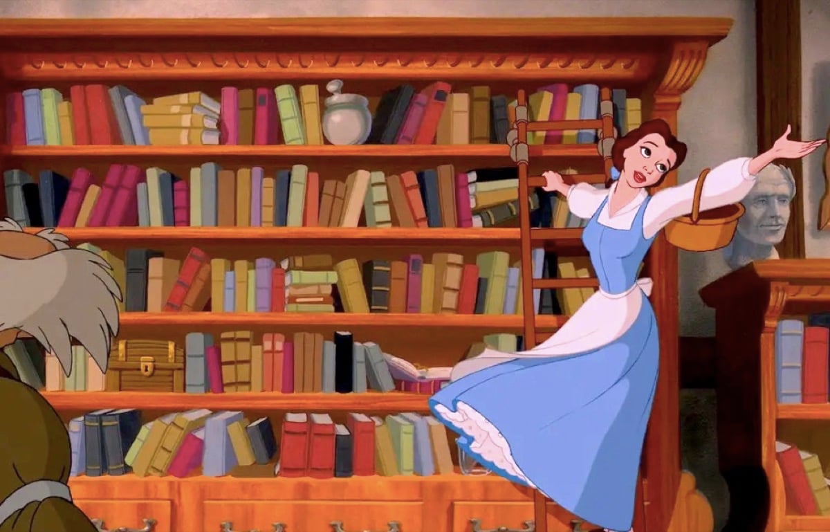 Belle singing on a ladder on a book shelf in Disney's Beauty and the Beast.
