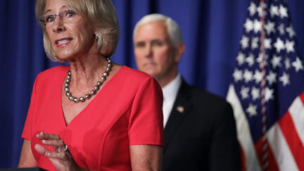 Betsy DeVos speaks as Vice President Mike Pence listens during a press briefing