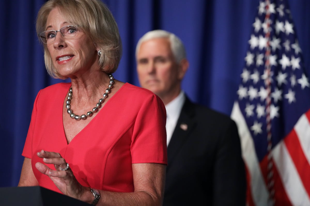 Betsy DeVos speaks as Vice President Mike Pence listens during a press briefing