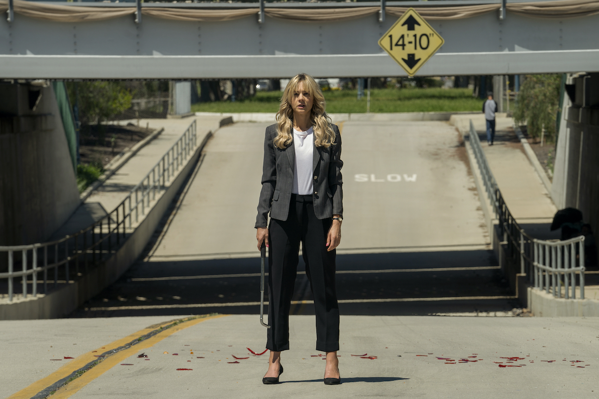 Carey Mulligan as Cassie in PromisingYoung Woman stands in the middle of a road, holding a crowbar.