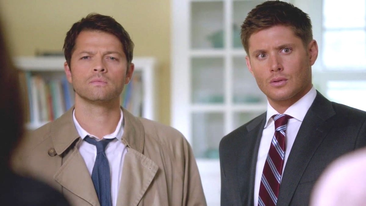 Castiel and Dean stand next to each other in The CW's Supernatural.
