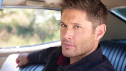 Dean Winchester sitting in the driver's seat of his car, smoldering at the camera in The CW's Supernatural finale.