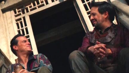 Lee Scoresby (Andrew Scott) and John Parry (Lin-Manuel Miranda) sit on a set of stairs and gaze at each other in HBO's His Dark Materials.