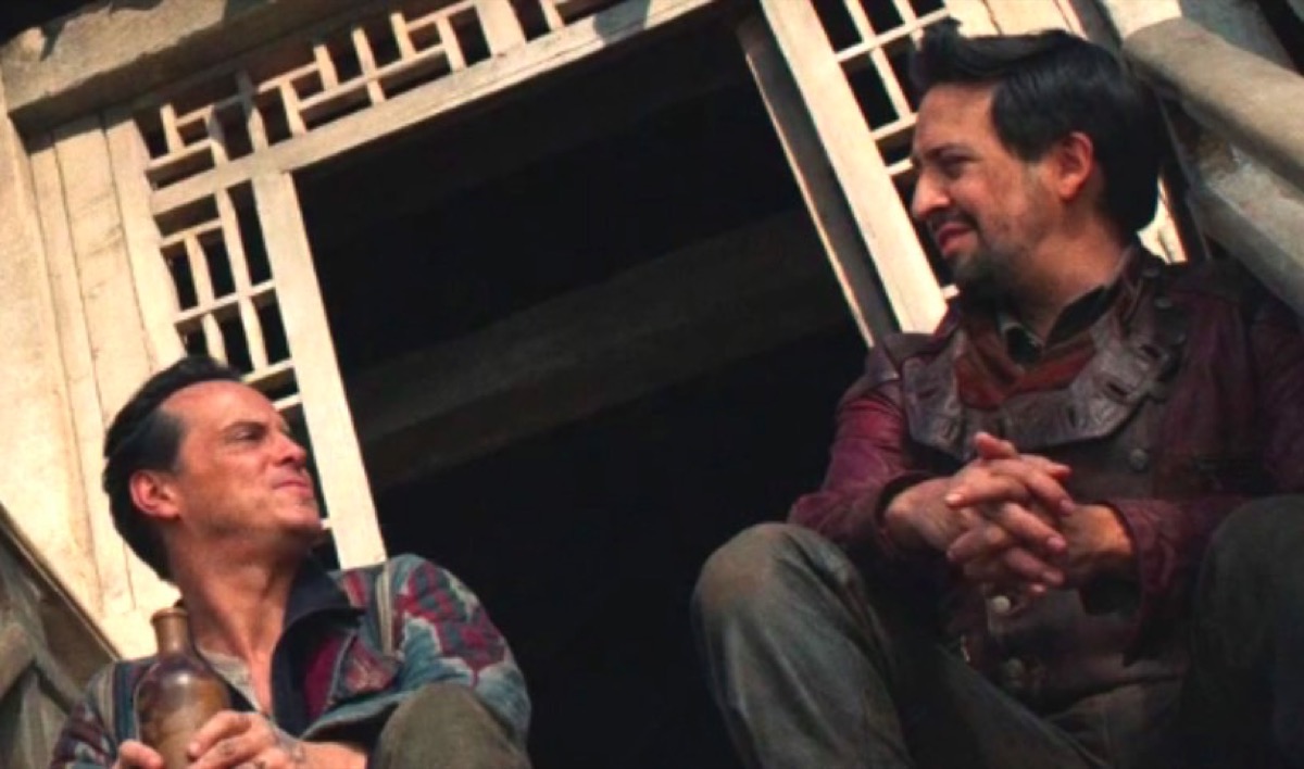 Lee Scoresby (Andrew Scott) and John Parry (Lin-Manuel Miranda) sit on a set of stairs and gaze at each other in HBO's His Dark Materials.