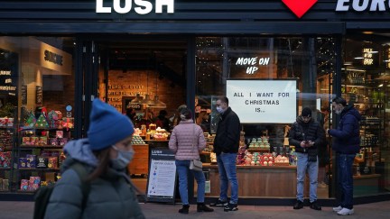 Shoppers wait to enter a Lush cosmetics store with a Christmas theme on Black Friday weekend