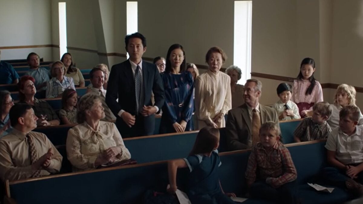 A korean family stand surrounded by white people in a church in minari