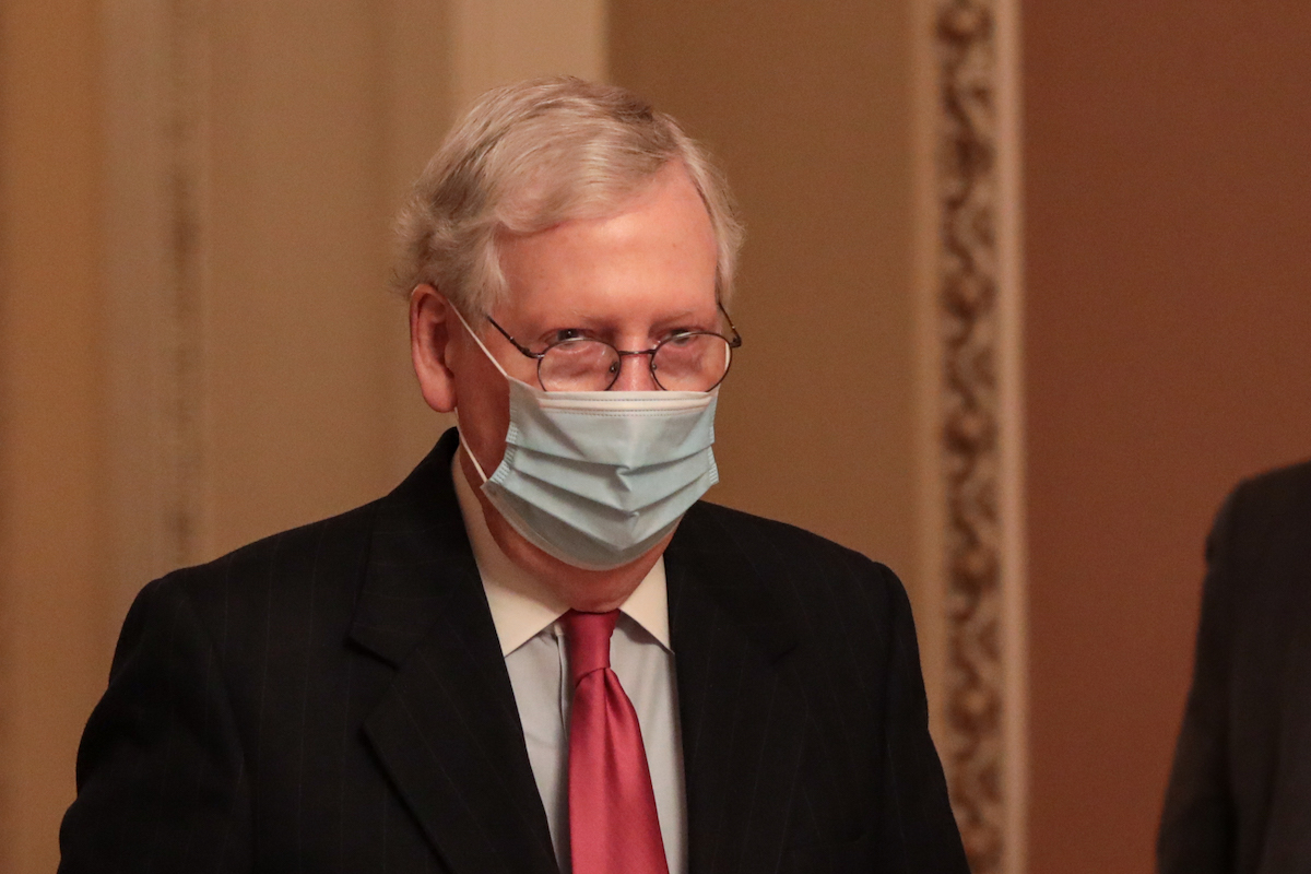 Mitch McConnell glares from under a mask.