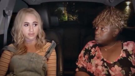 Maria Bakalova as Tutar in Borat 2 sits in a car with Jeanise Jones.