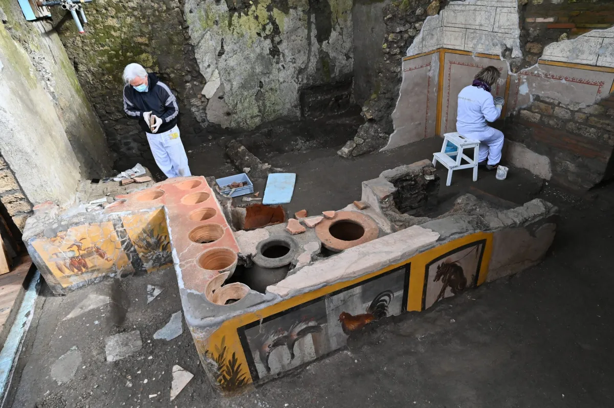 Restorers work in the new area of the 'Thermopolium' at the archaeological site of Pompeii, near Naples, on January 25, 2021. - The 'Thermopolium' used to offer a quick midday meal with hot food and drinks to the Romans away from home. (Photo by Andreas SOLARO / AFP) (Photo by ANDREAS SOLARO/AFP via Getty Images)