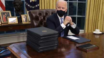 WASHINGTON, DC - JANUARY 20: U.S. President Joe Biden prepares to sign a series of executive orders at the Resolute Desk in the Oval Office just hours after his inauguration on January 20, 2021 in Washington, DC. Biden became the 46th president of the United States earlier today during the ceremony at the U.S. Capitol. (Photo by Chip Somodevilla/Getty Images)