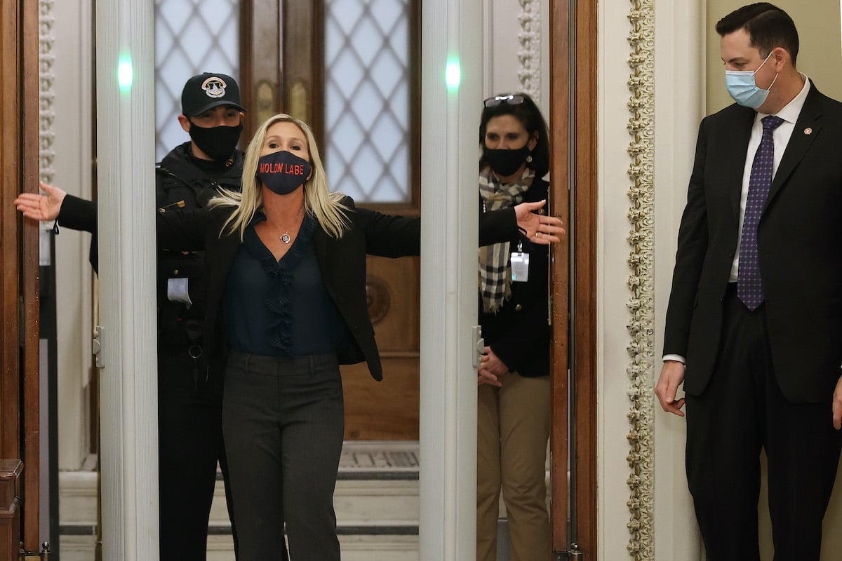 Rep. Marjorie Taylor Greene is searched by U.S. Capitol Police after setting off the metal detector. She is wearing a mask reading "Molon Labe," meaning "come and take them."
