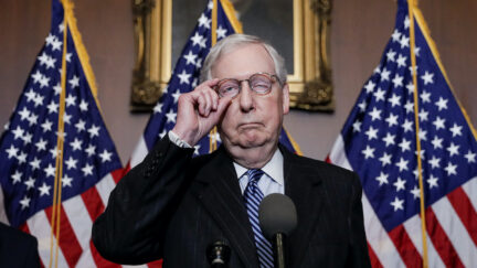 Mitch McConnell looks like his face is falling apart during a press conference.