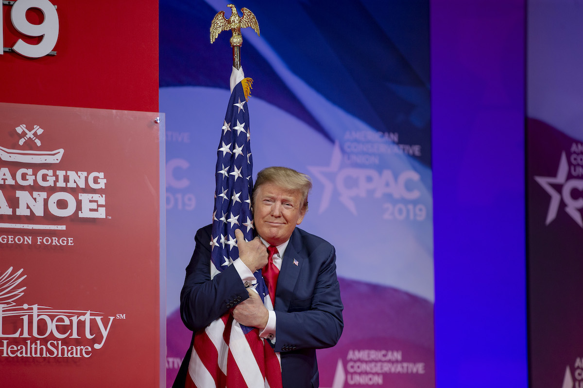 Donald Trump proves how much he loves America by hugging a flag and smirking