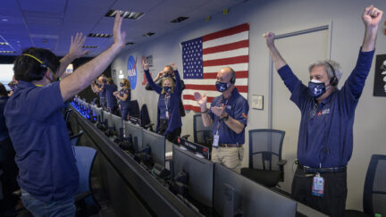 PASADENA, CA - FEBRUARY 18: In this handout image provided by NASA, members of NASA's Perseverance rover team react in mission control after receiving confirmation the spacecraft successfully touched down on Mars, , February 18, 2021 at NASA's Jet Propulsion Laboratory in Pasadena, California. A key objective for Perseverance's mission on Mars is astrobiology, including the search for signs of ancient microbial life. The rover will characterize the planet's geology and past climate, paving the way for human exploration of the Red Planet, and be the first mission to collect and cache Martian rock and regolith. (Photo by Bill Ingalls/NASA via Getty Images)