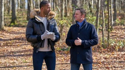 Chris Harrison and Bachelor Matt James stand in the woods, looking at each other.