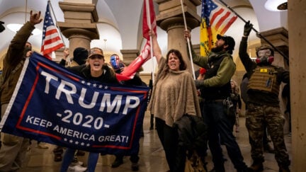 Trump supporters wave a Trump 2020 flag during the Capitol riot.