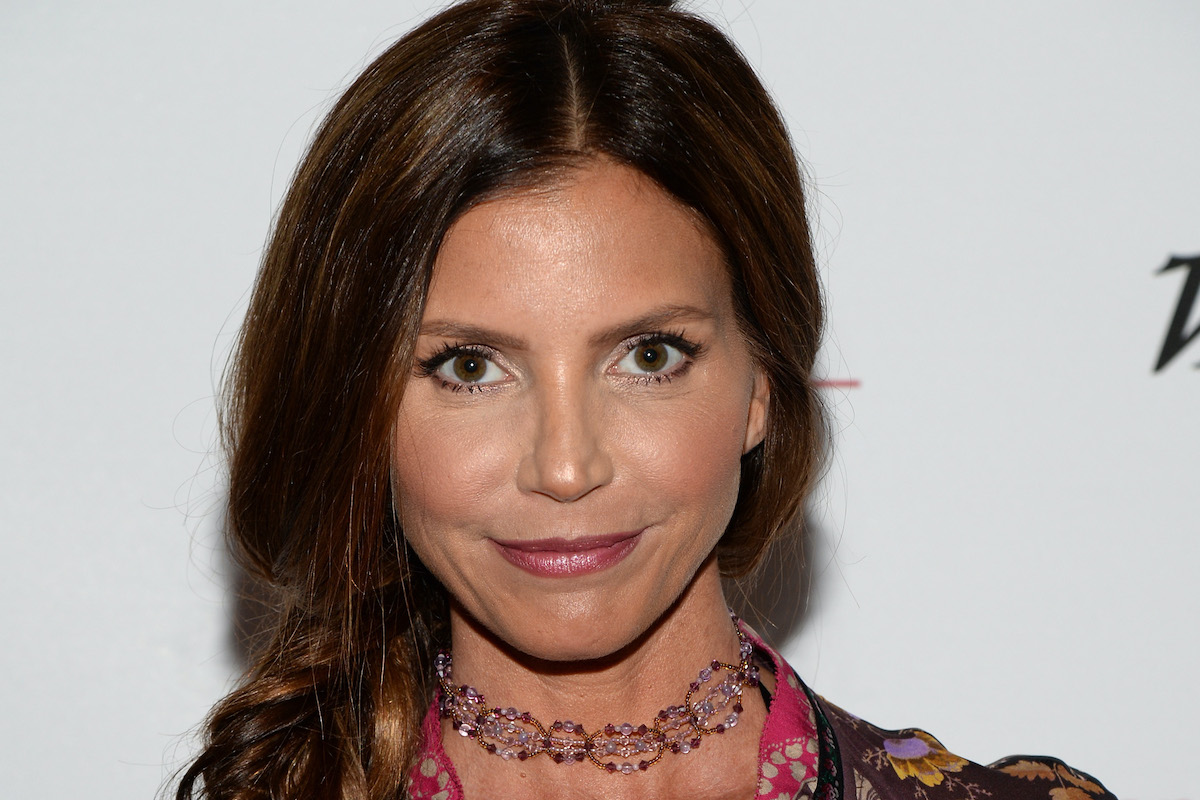 Charisma Carpenter looks at the camera while walking a red carpet for an event.