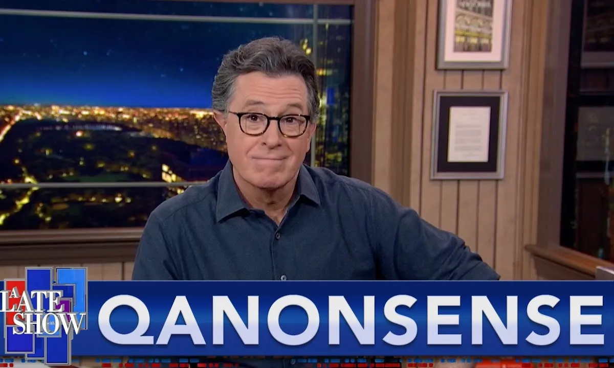 A still from The Late Show showing Stephen Colbert smirking above a chryon reading "QANONSENSE"