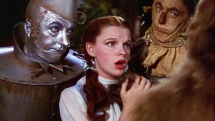Dorothy, the Tin Man, and the Scarecrow look scared/disapproving in a still from The Wizard of Oz