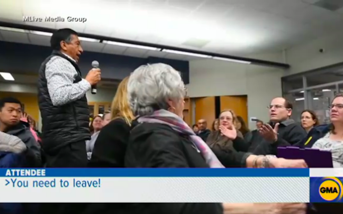 A man hurls a racist comment at another parent during a school meeting about racism.