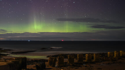 LOSSIEMOUTH, SCOTLAND - FEBRUARY 20: The Aurora Borealis is seen above WW2 beach defenses on February 20, 2021 in Lossiemouth, Scotland. The Aurora Borealis, more commonly known as the Northern Lights, occurs when solar winds drive charged particles from the sun which strike atoms and molecules in Earths atmosphere causing the light show. (Photo by Peter Summers/Getty Images)