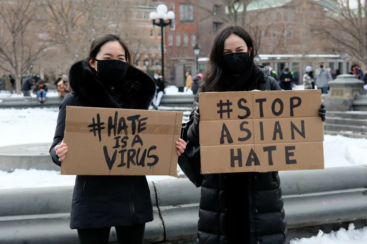 NEW YORK, NEW YORK - FEBRUARY 20: Protestors hold signs that read "hate is a virus" and "stop Asian hate" at the End The Violence Towards Asians rally in Washington Square Park on February 20, 2021 in New York City. Since the start of the coronavirus pandemic, violence towards Asian Americans has increased at a much higher rate than previous years. The New York City Police Department (NYPD) reported a 1,900% increase in anti-Asian hate crimes in 2020. (Photo by Dia Dipasupil/Getty Images)