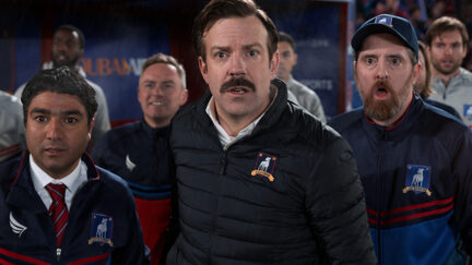 Ted Lasso, Coach Beard, and Nate gape at a soccer game.