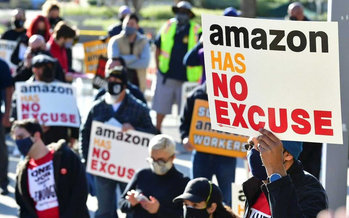 Union organizers hold signs reading "Amazon has no excuse" during a rally