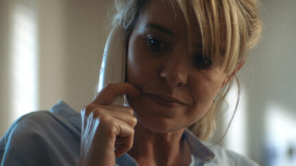 Brea Grant in Lucky grimaces while talking on a landline phone.