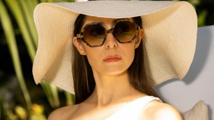 Cristin Milioti as Hazel Green in Made for Love, wearing large sunglasses and a giant white sun hat.