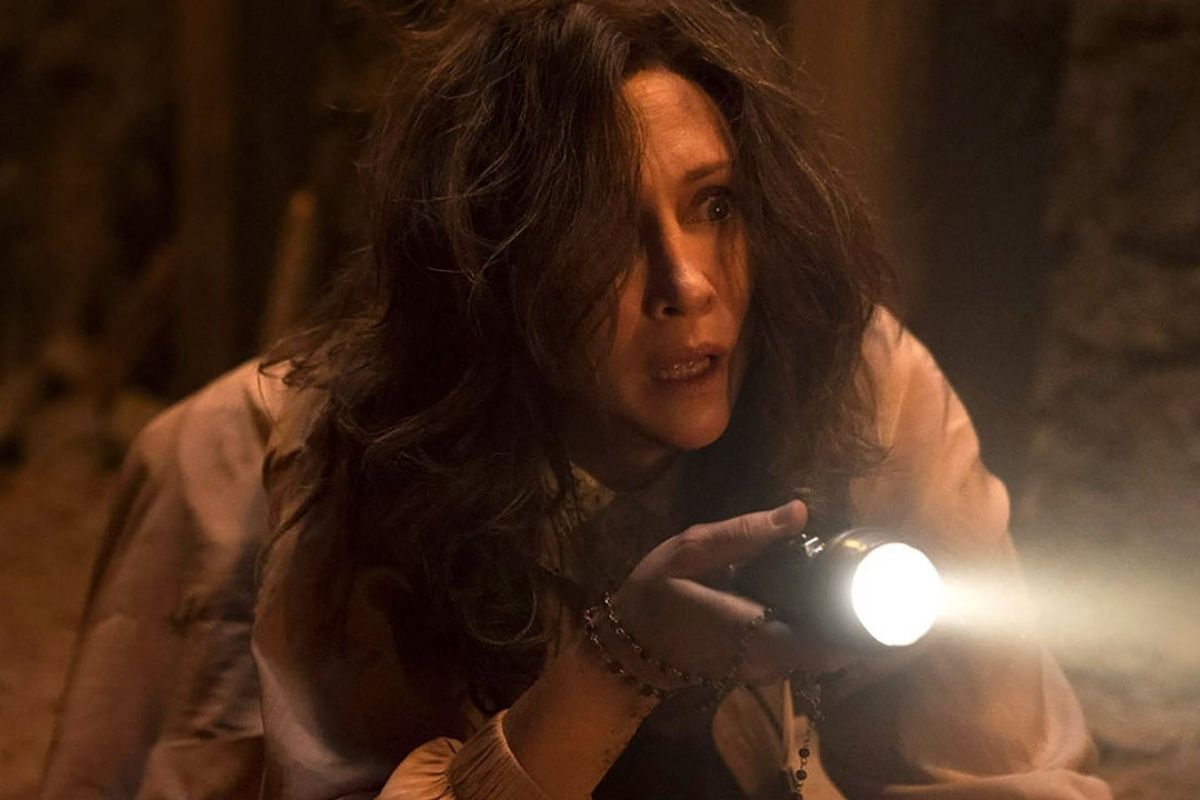 A woman holding a flashlight in The Conjuring: The Devil Made Me Do It