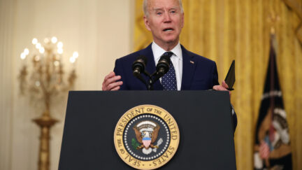 Joe Biden talks from a podium with the presidential seal