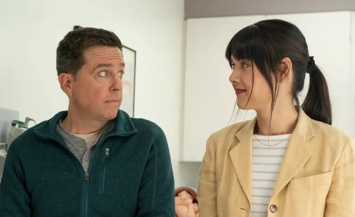 Patti Harrison and Ed Helms pull faces at each other in Together Together.