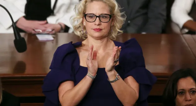 (image: Mario Tama/Getty Images) Sen. Krysten Sinema (D-AZ) applauds during the State of the Union