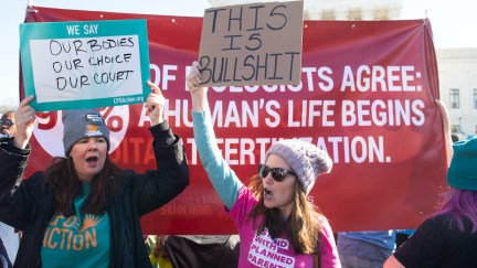 A pro-choice protester in a Planned Parenthood shirt holds a sign saying 