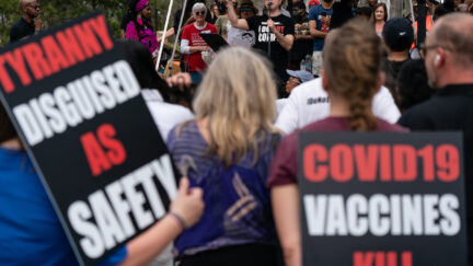 People are seen at a protest against masks, vaccines, and vaccine passports
