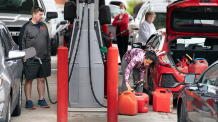 A woman fills her trunk with gas canisters while other motorists silently judge her.