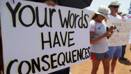 A protester holds a sign reading 