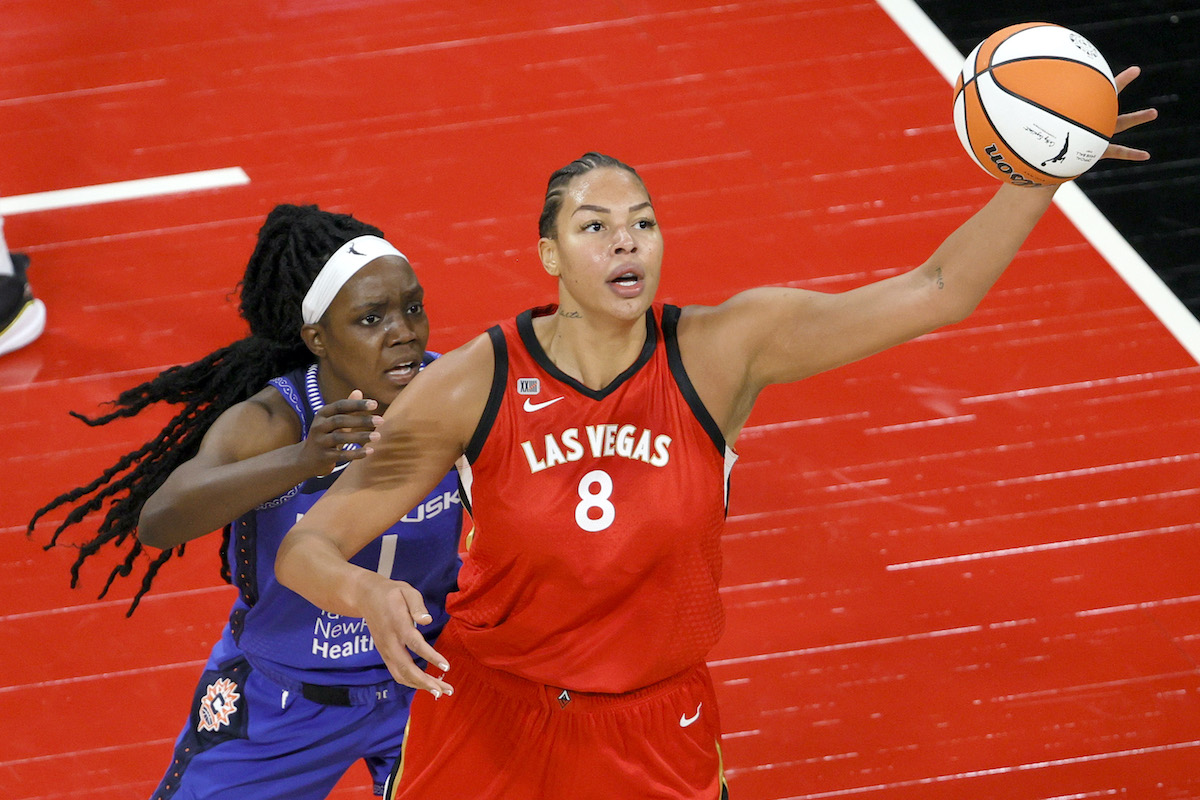 Liz Cambage #8 of the Las Vegas Aces catches a pass under pressure from Beatrice Mompremier #1 of the Connecticut Sun during their game