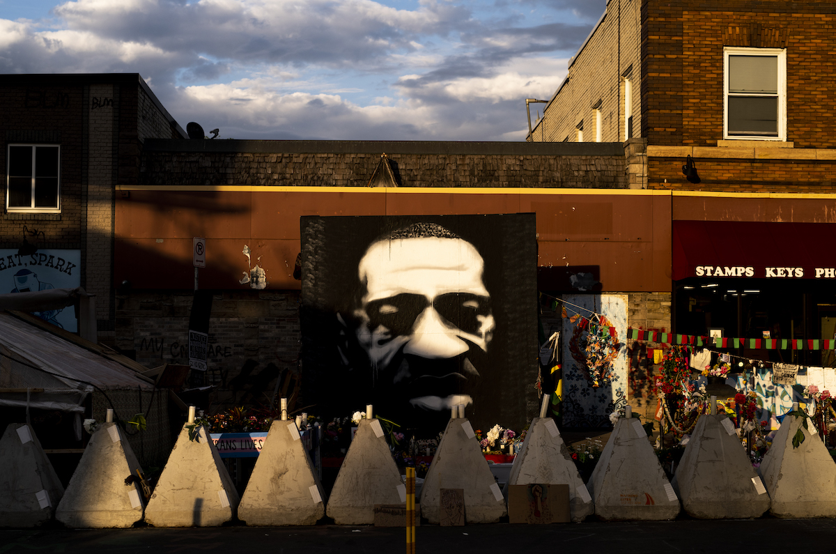 Sunlight falls on a portrait of George Floyd at George Floyd Square