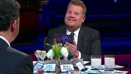 James Corden sits at a table with various exotic foods.