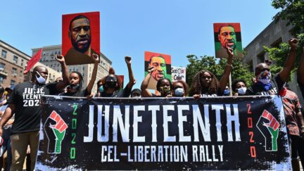 Protestors hold pictures of George Floyd as they march during a Juneteenth rally