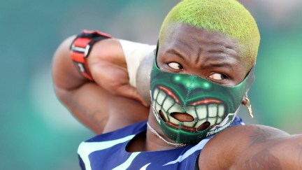 Raven Saunders wears a Hulk mask with dyed green shaved hair while throwing a shot put during the Olympic trials.