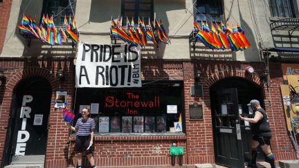 The Stonewall Inn in New York flies LGBTQIA flags and a sign reading 
