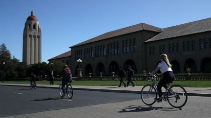 Cyclists ride by Hoover Tower on the Stanford University campus